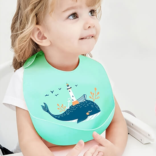 Fillette croisant les doigts portant un bavoir bébé baleine