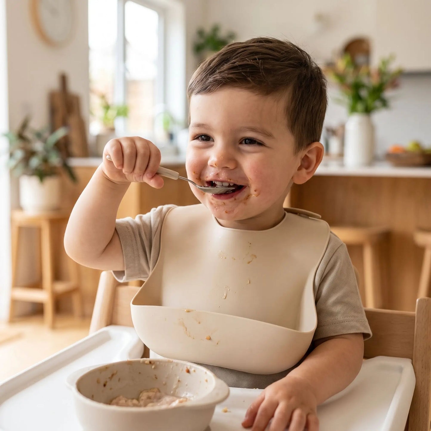 Bavoir bébé beige garçon qui mange à la cuillère