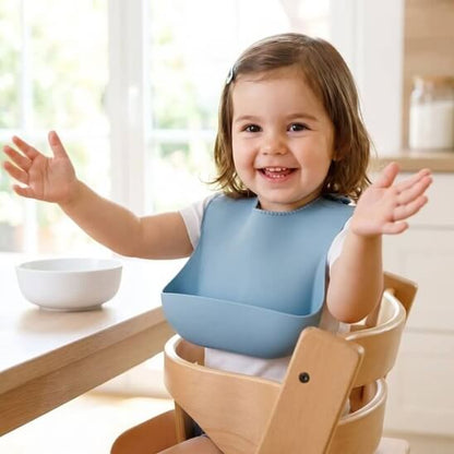 Fillette qui porte le bavoir bébé bleu souriante avec les bras ouverts
