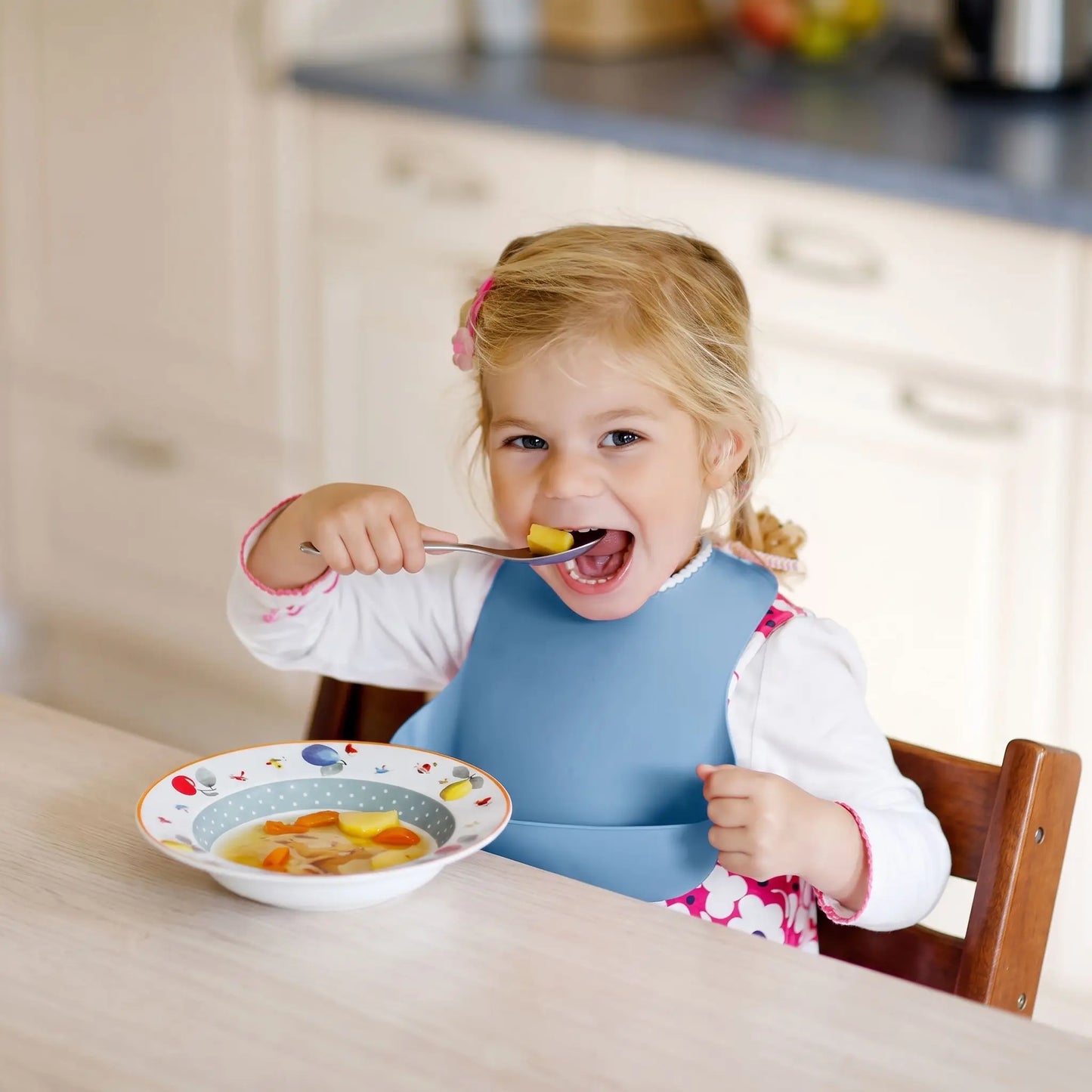 Bavoir bébé bleu fillette qui mange