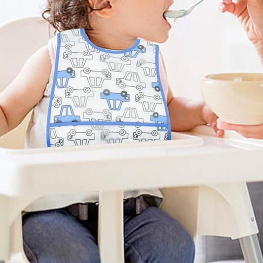 Fillette portant un bavoir bébé voitures qui mange