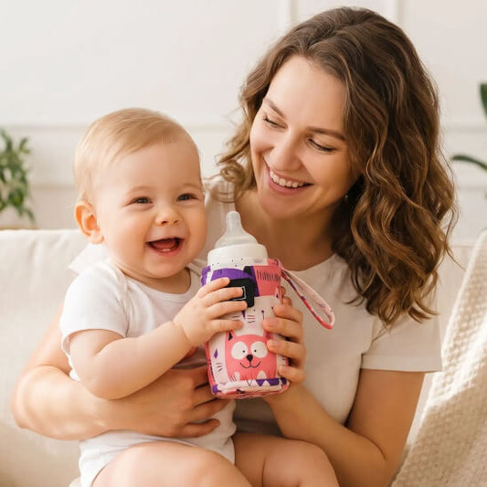 Bébé avec son chauffe biberon portable rose sur sa maman