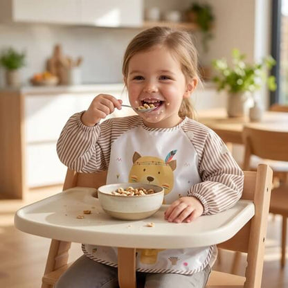 Fillette qui mange des céréales avec bavoir bébé marron ours