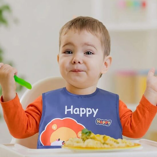 Garçon qui écarte les bras avec le bavoir bébé bleu