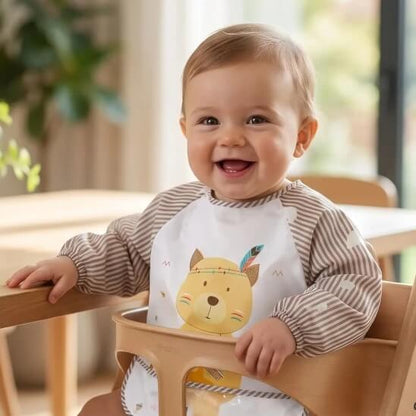 Garçon qui sourit avec bavoir bébé marron ours