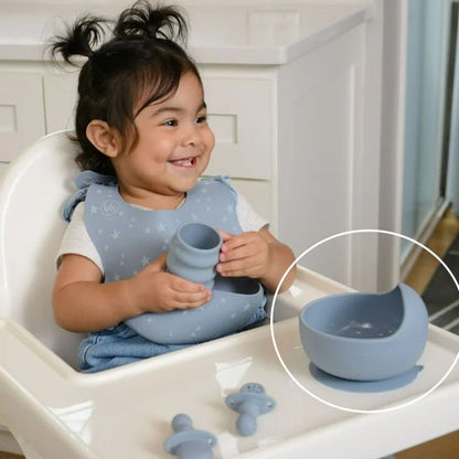 Fillette tiens un verre avec l'assiette bebe bleue
