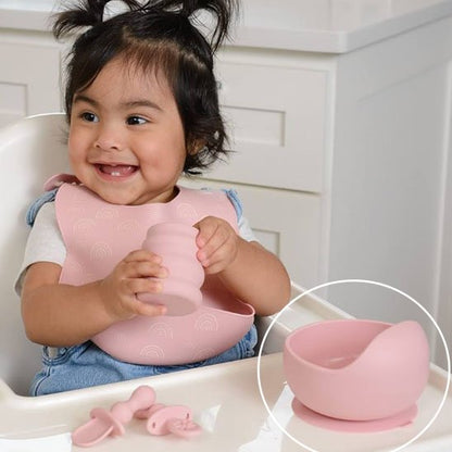 Fillette tiens un verre avec l'assiette bebe rose