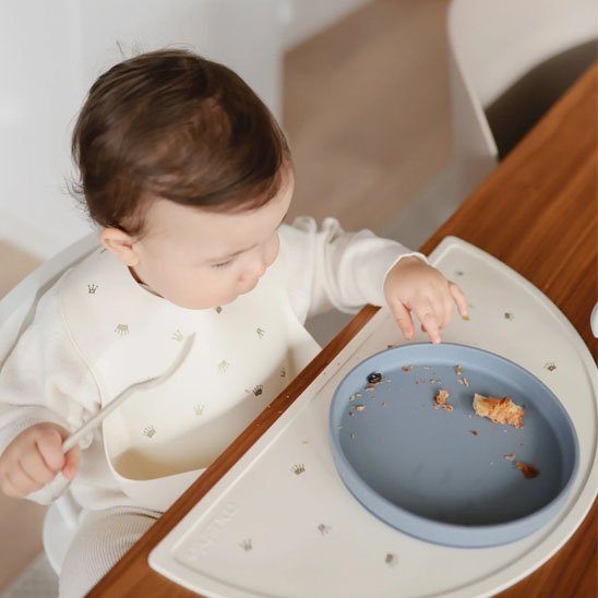 Garçon qui mange avec assiette bebe bleue
