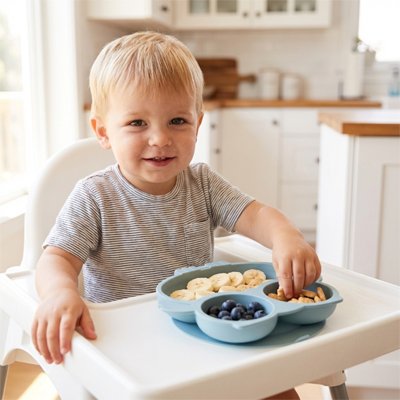 Garçon qui mange avecs ses doigts assiette bébé ventouse bleue